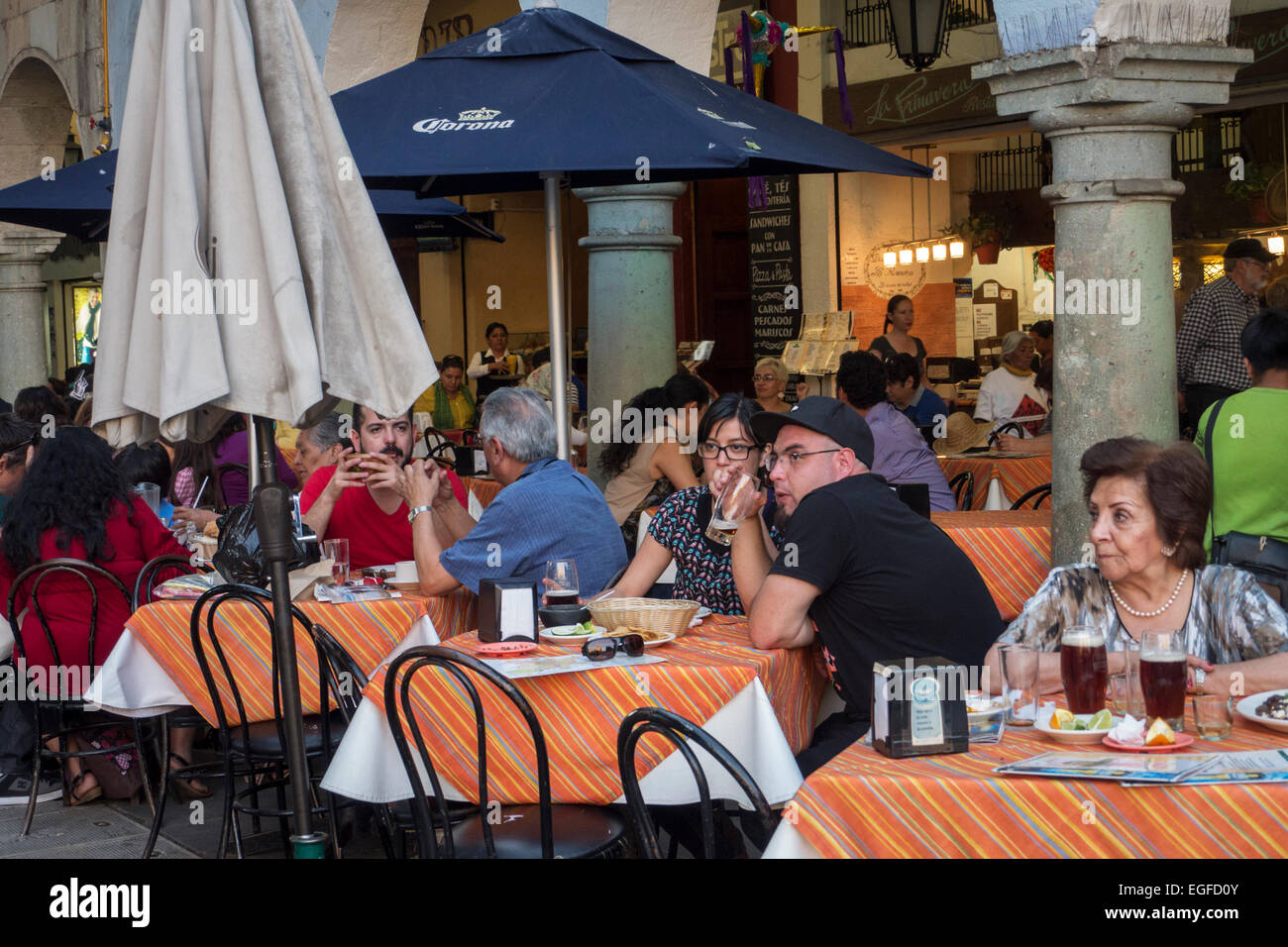 People sit in an outdoor restaurant in the Zocalo in Oaxaca, Mexico Stock Photo