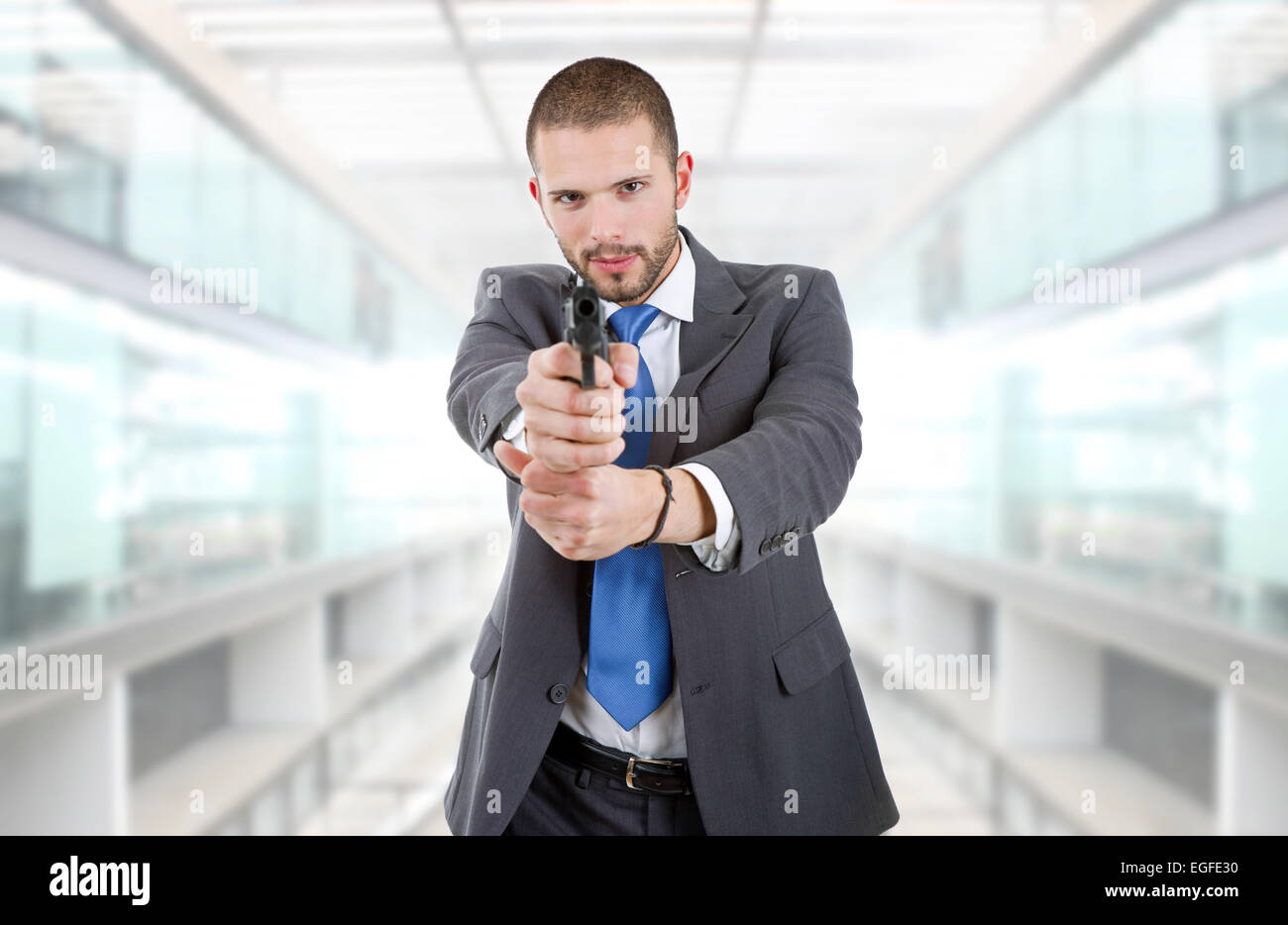 young businessman with a gun, at the office Stock Photo