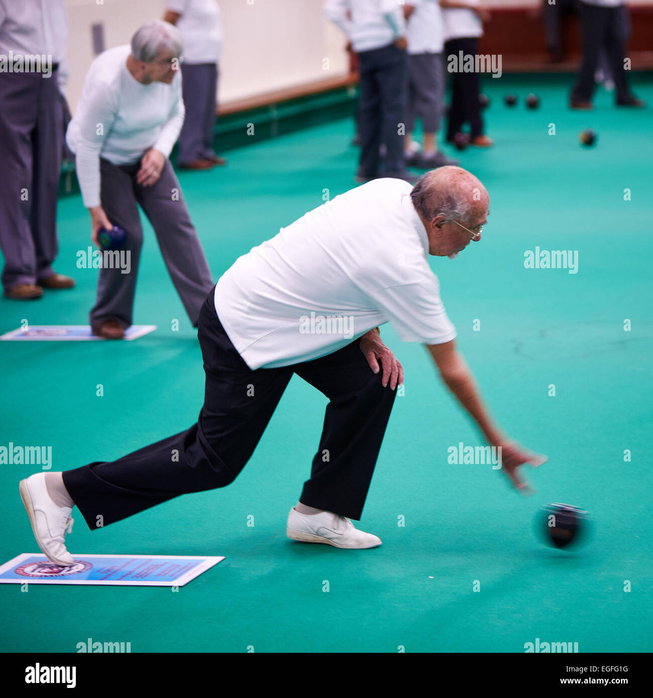 Members of the Oxford & District Indoor Bowls Club playing. Contains motion blur. Stock Photo