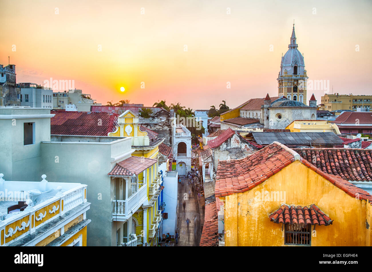 View over the rooftops of the old city of Cartagena during a vibrant sunset. The spire of Cartagena Cathedral stands tall and pr Stock Photo