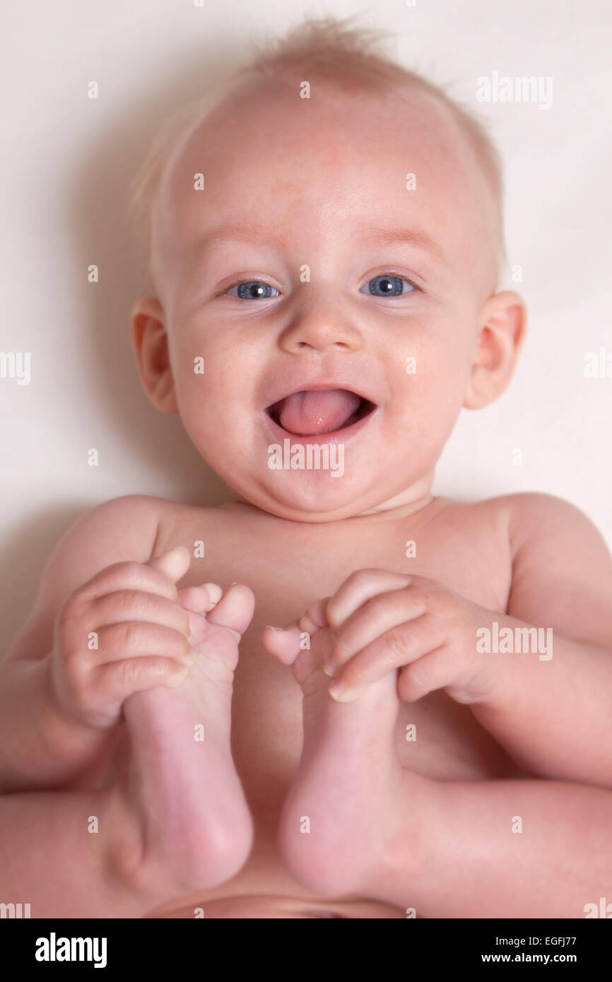 6 month old baby holding his toes Stock Photo