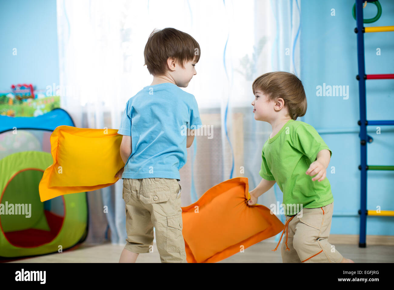 Two children playing with pillows Stock Photo
