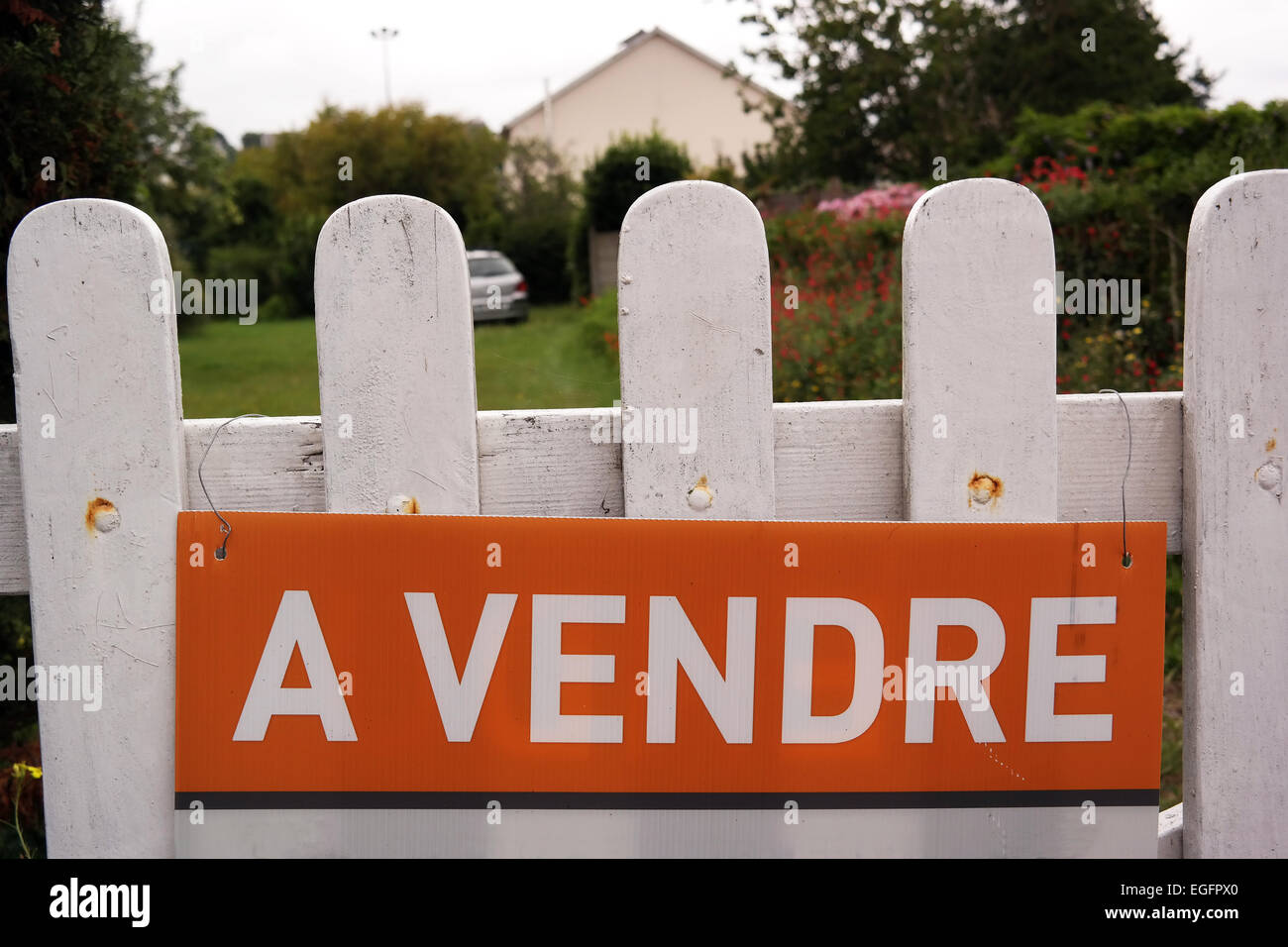 House for sale sign at a fence of a french home in Brittany, France
