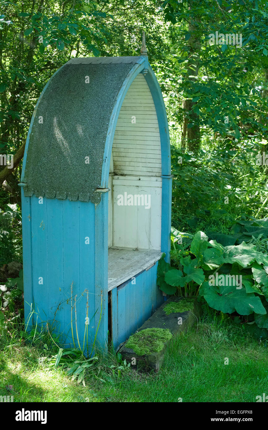 Covered Wooden Garden Seat in the Shape of a Boat Stock Photo