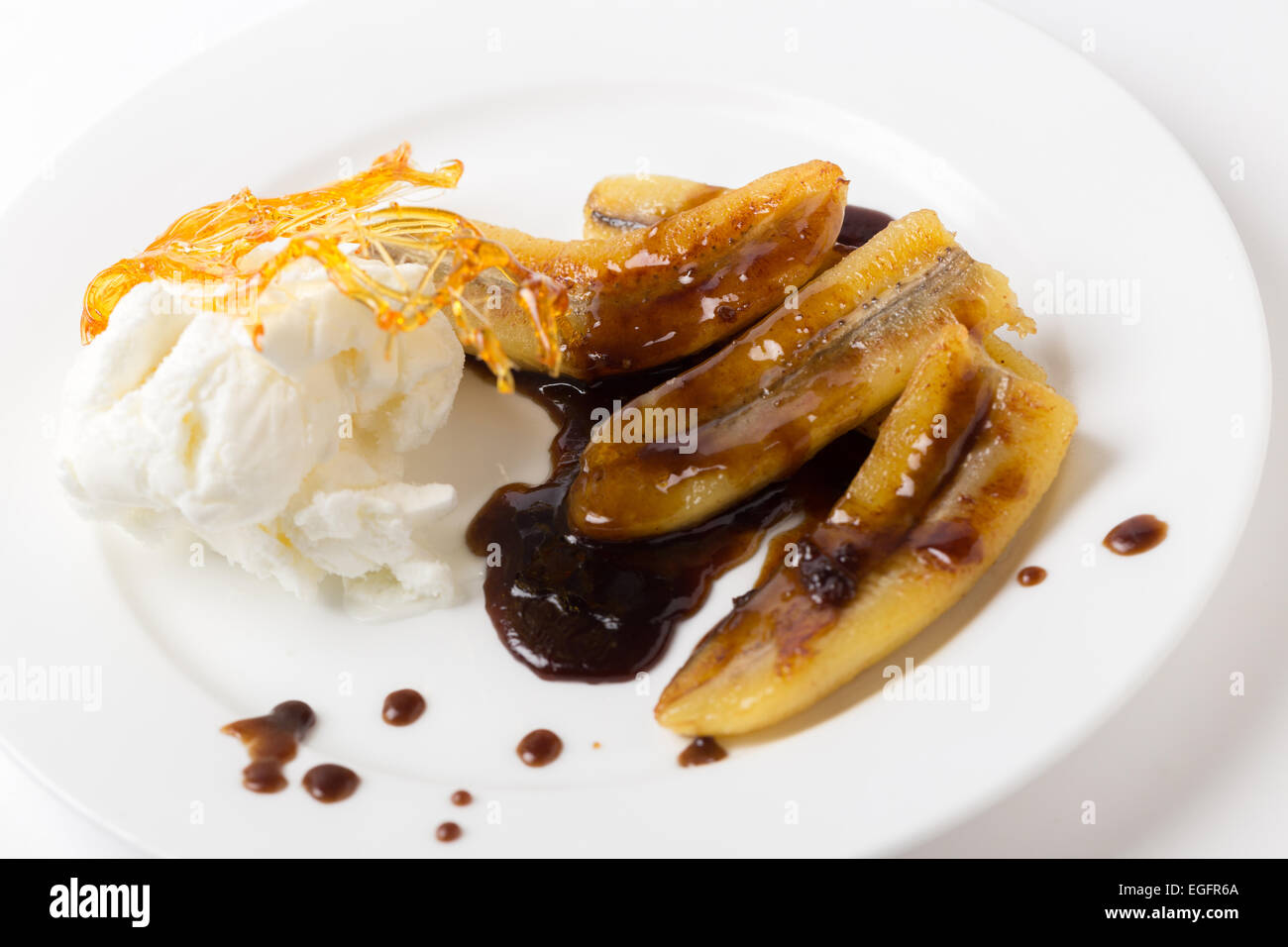 Fried bananas with a toffee sauce, ice cream and a caramelised sugar decoration. Stock Photo