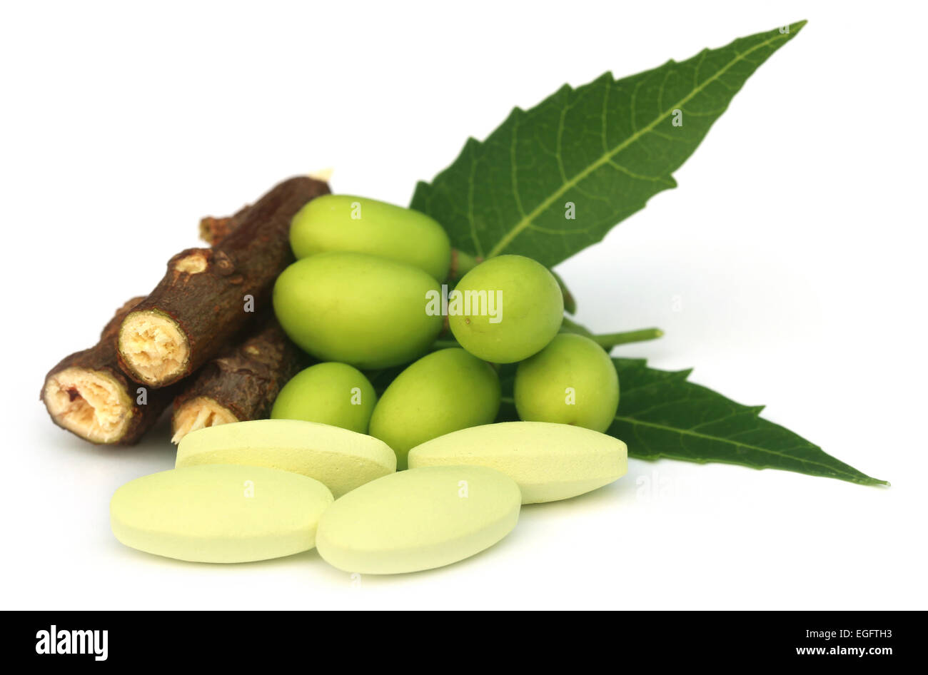 Medicinal neem fruits with tablets over white background Stock Photo