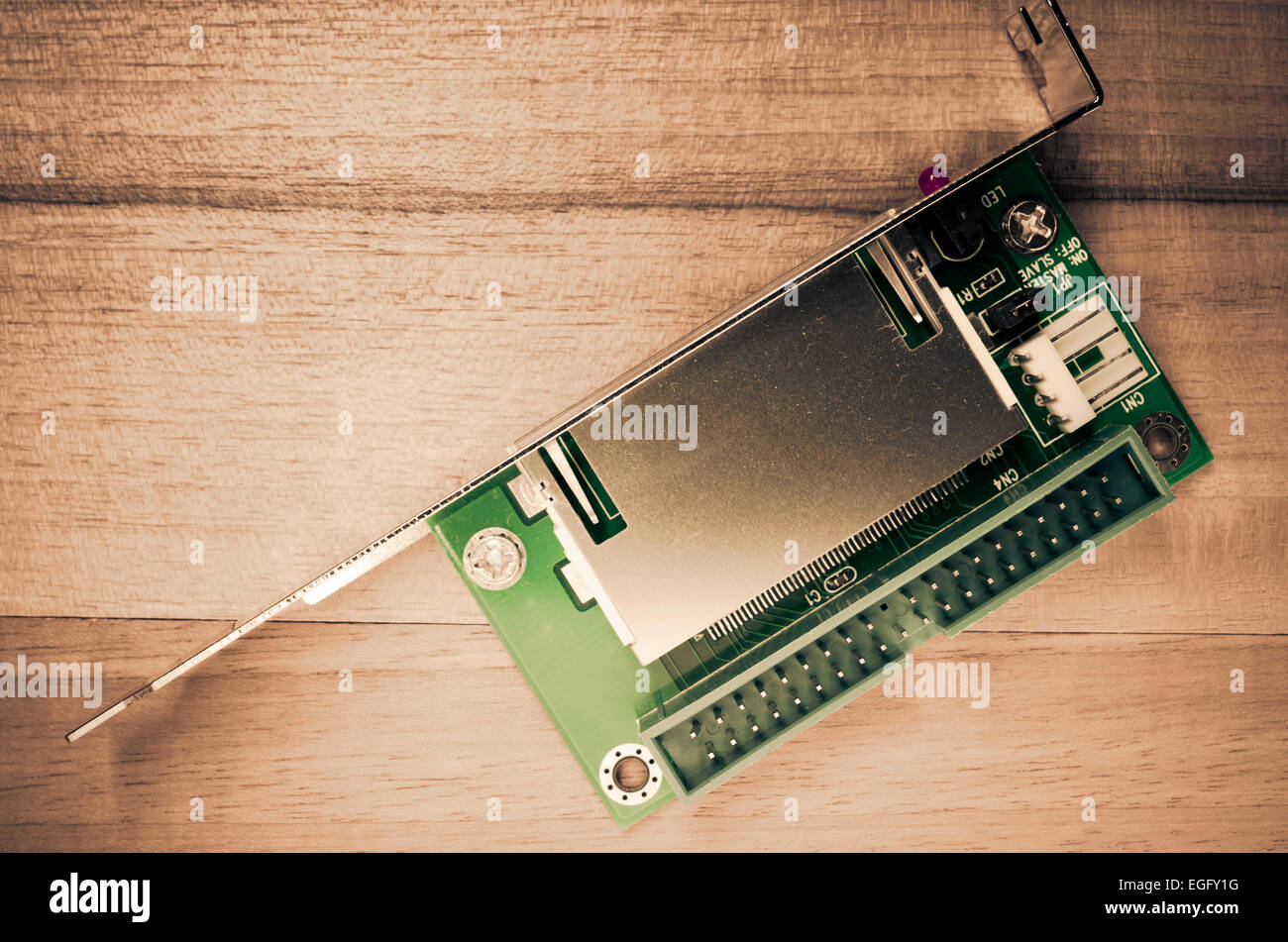 detail of a pc expansion card with connector on a wood background - flash card reader Stock Photo