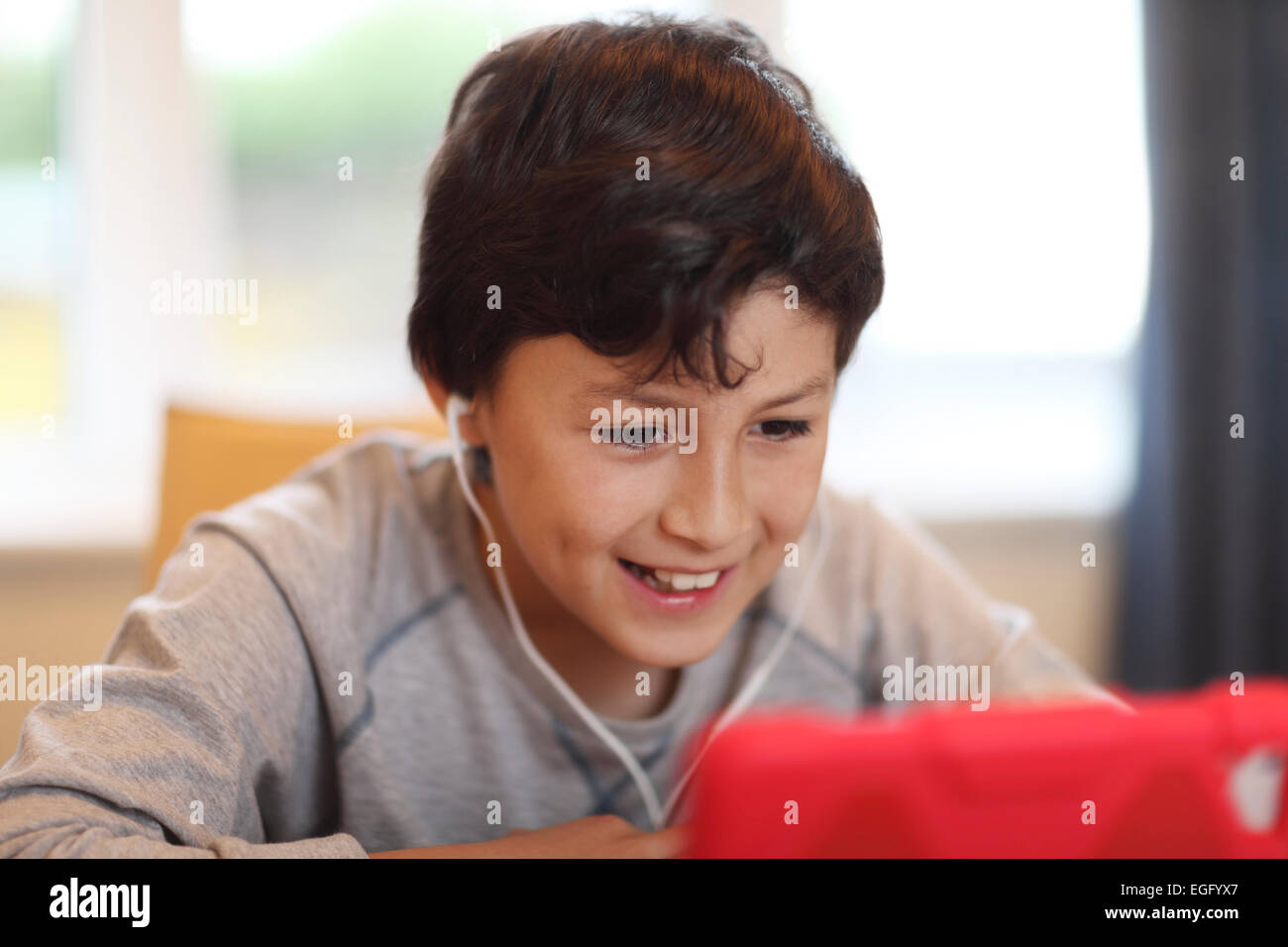 Young smiling boy playing with tablet computer Stock Photo