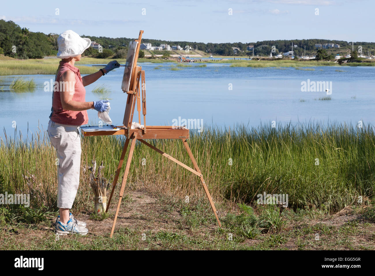 Female artist painting scenic Duck Creek in Wellfleet, Massachusetts. Stock Photo