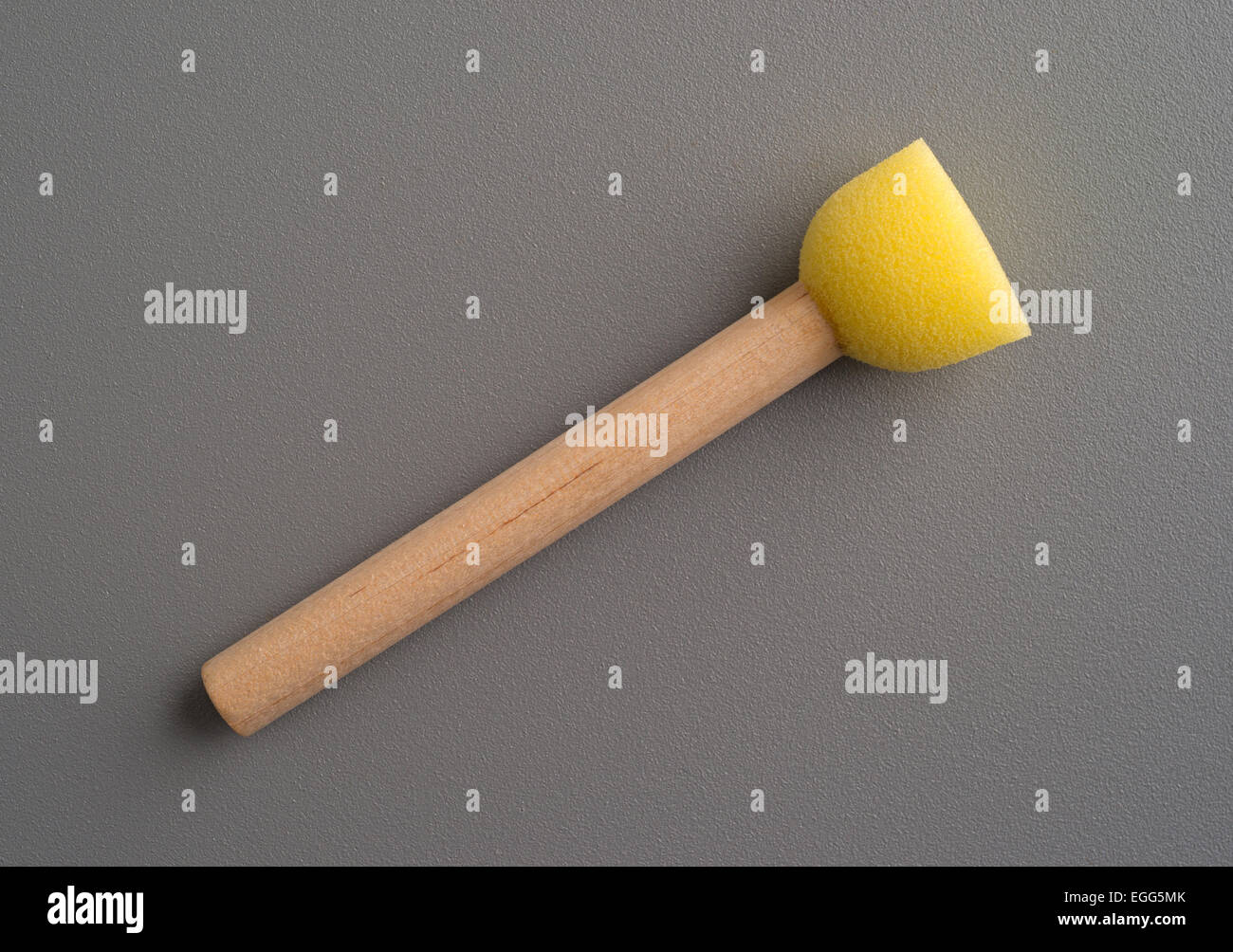 A small wood handle stencil brush on a gray background. Stock Photo