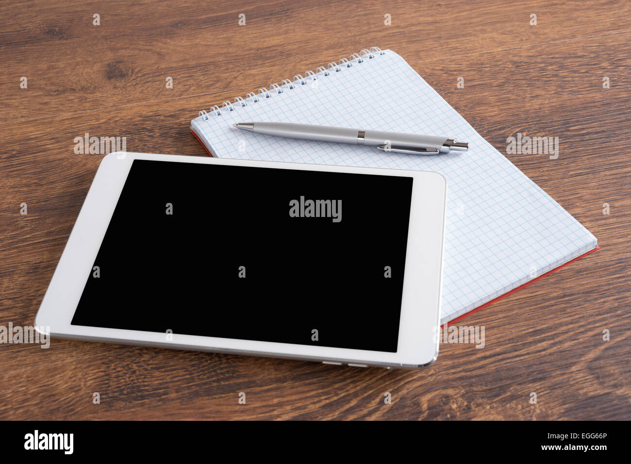 White digital tablet with pen and notebook on the table Stock Photo