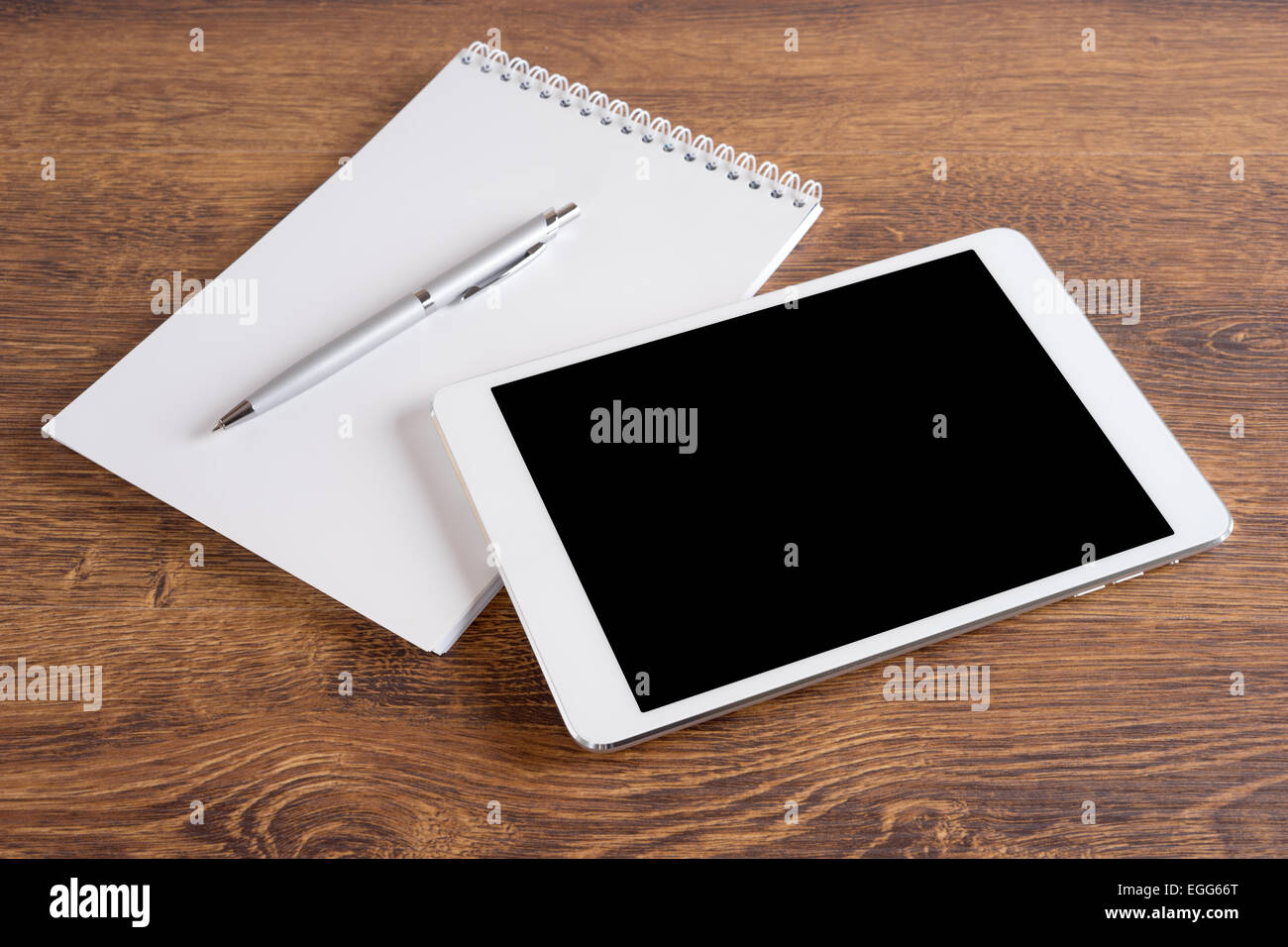 White digital tablet with pen and notebook on the table Stock Photo