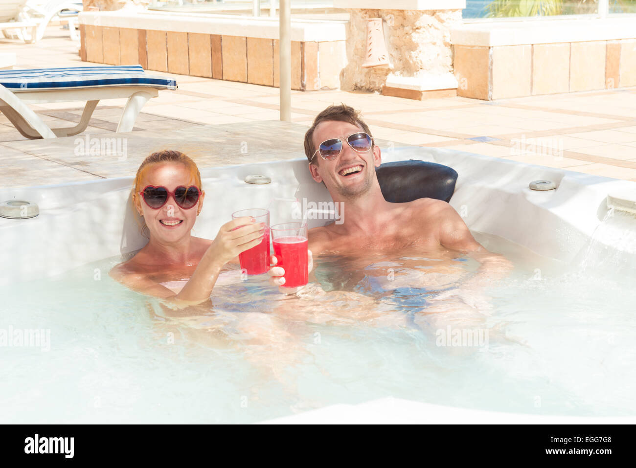 Smiling loving couple relaxing together on a jacuzzi pool at tourist resort Stock Photo