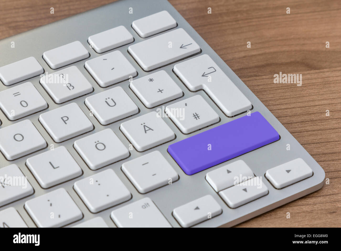 Large blue button of a modern keyboard on a wooden desktop Stock Photo