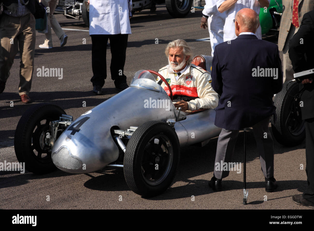 Sir Stirling Moss (back to camera) rests on his shooting stick on the grid for the Parade of Legends / Goodwood Revival / UK Stock Photo