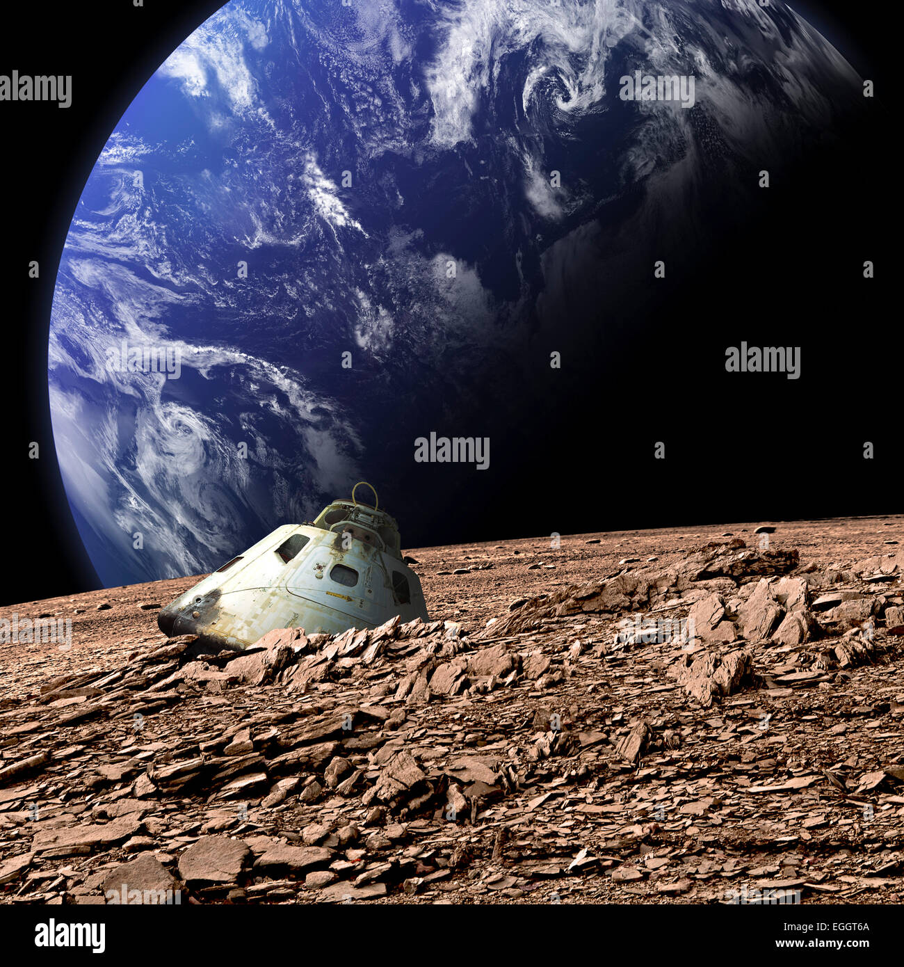 A scorched space capsule lies abandoned on a barren moon. An Earth-like planet covered in water rises in the background. Stock Photo