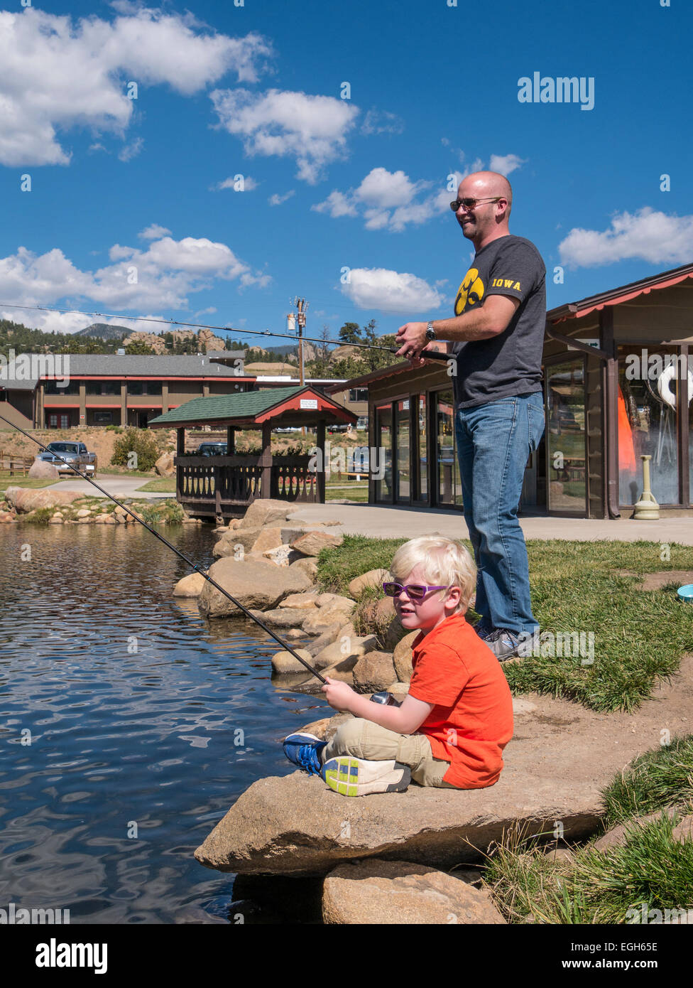 Father and son fish the pond at Trout Haven, Estes Park, Colorado Stock