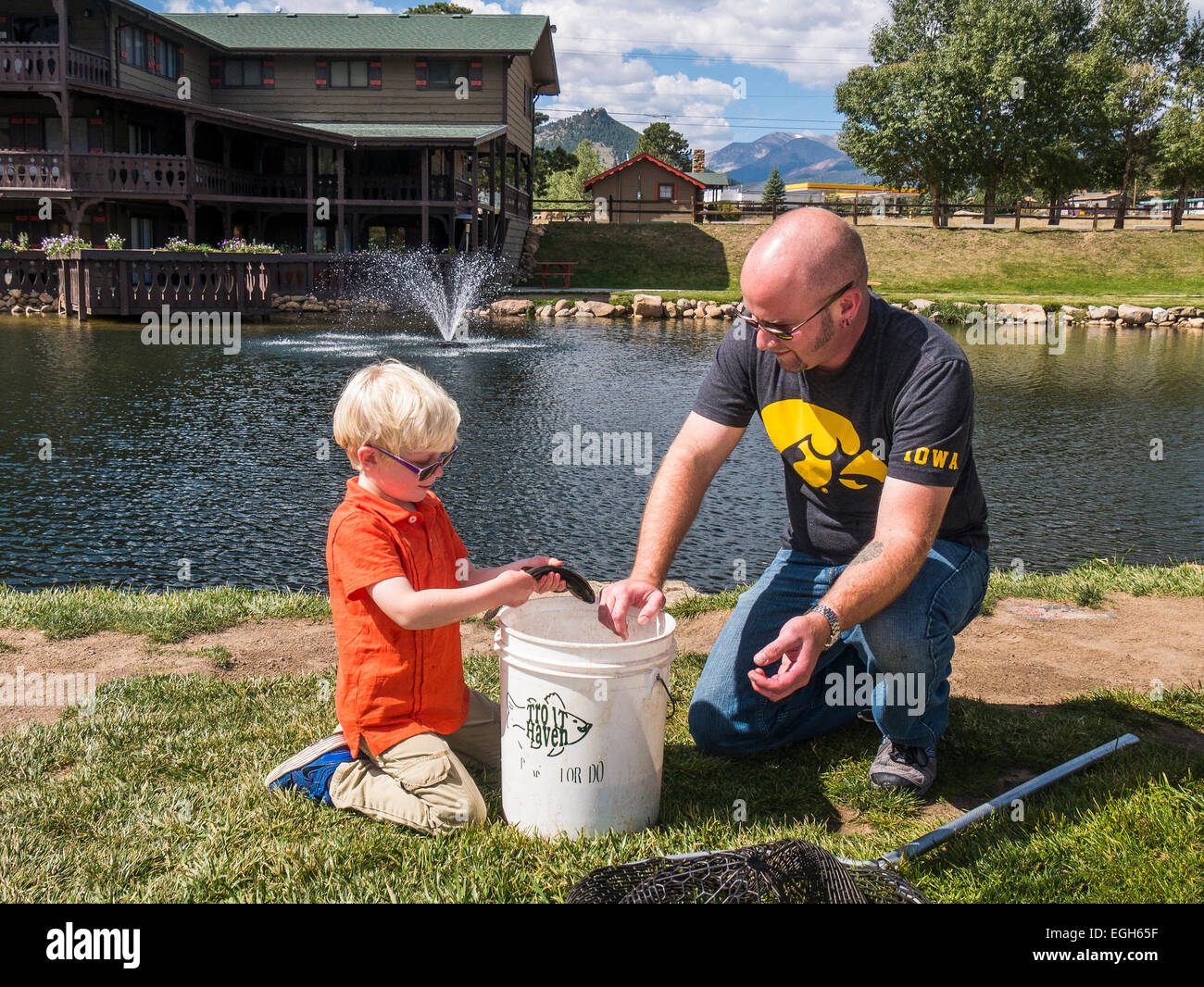 Father and son look at their catch from the pond at Trout Haven, Estes