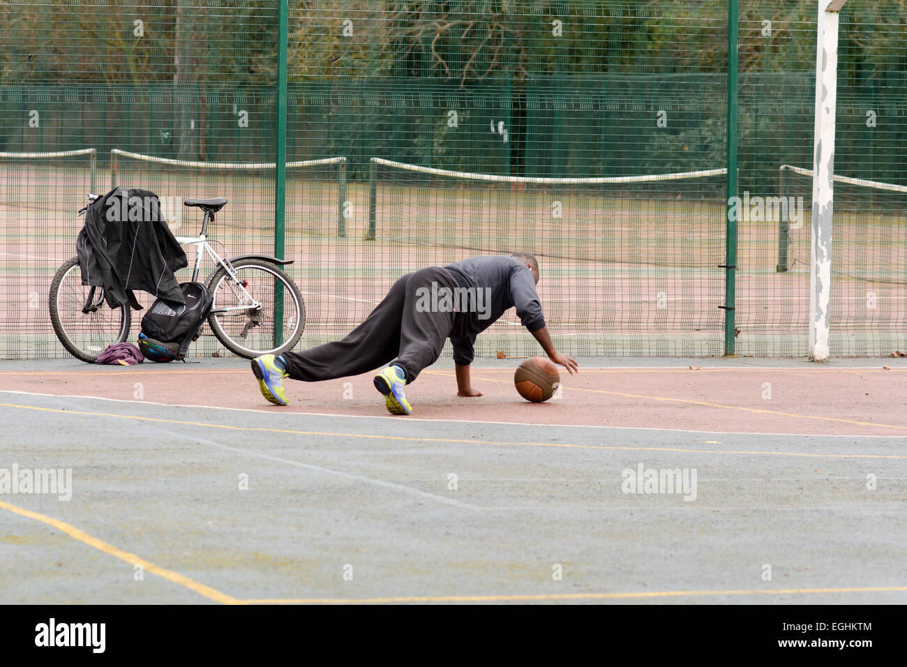 Man doing pressups with basketball on basketball court in Bedford Park, Bedford, Bedfordshire
