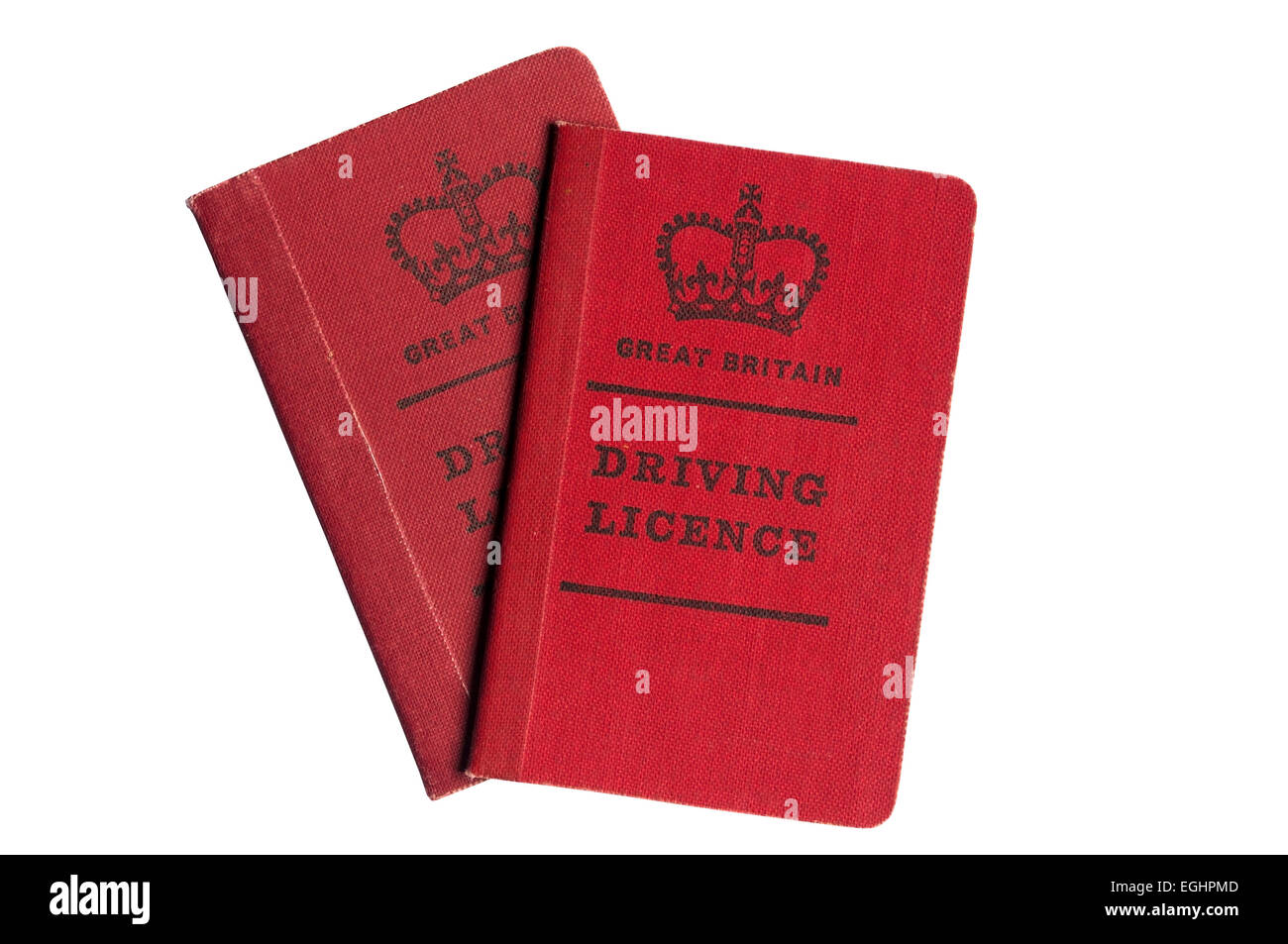 A pair of old style red cloth covered British driving licences. Stock Photo