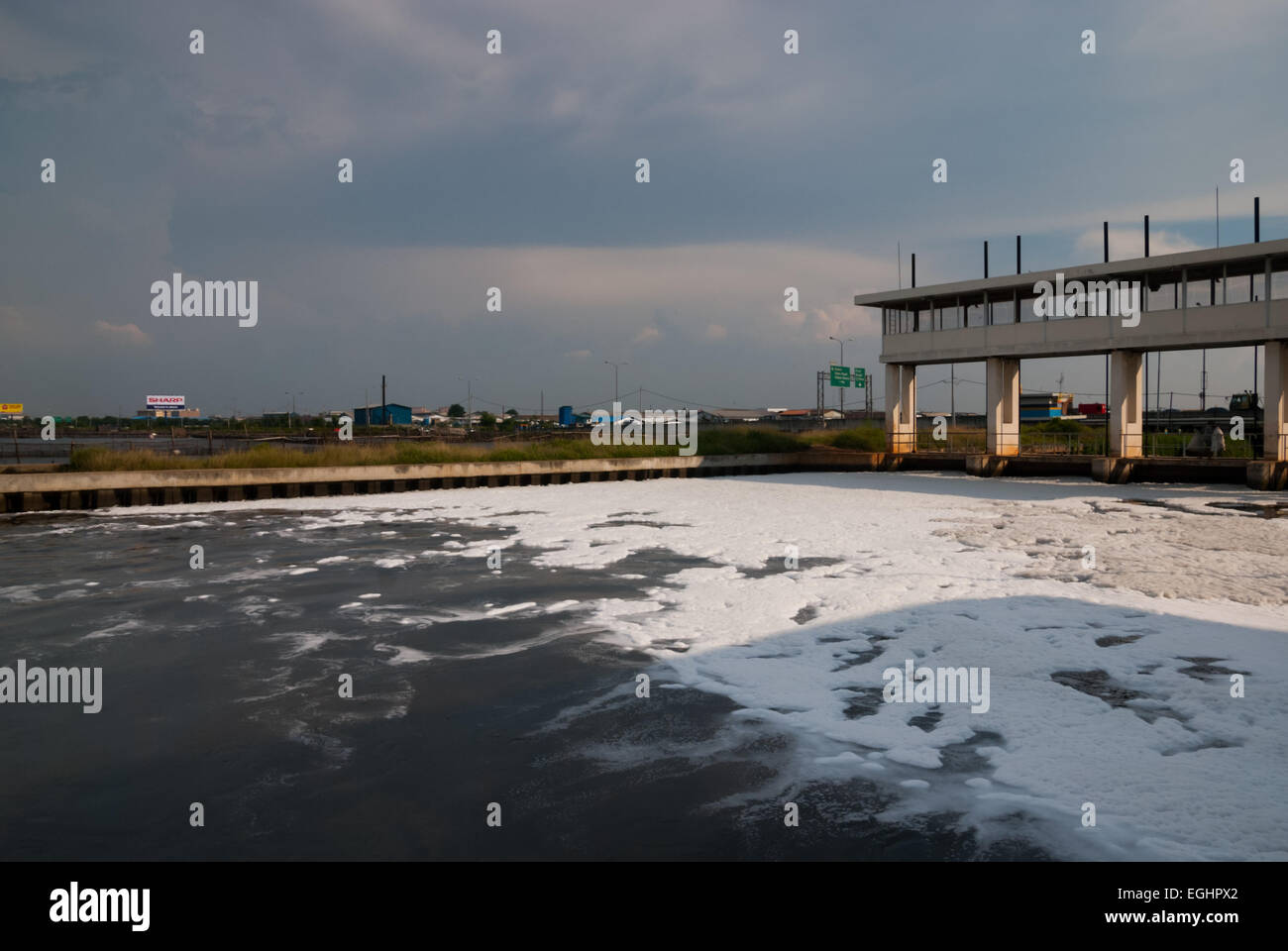 White foams covering a waterway close to a part of the highway leading to Jakarta's Soekarno-Hatta International Airport, in Jakarta coastal area. Stock Photo