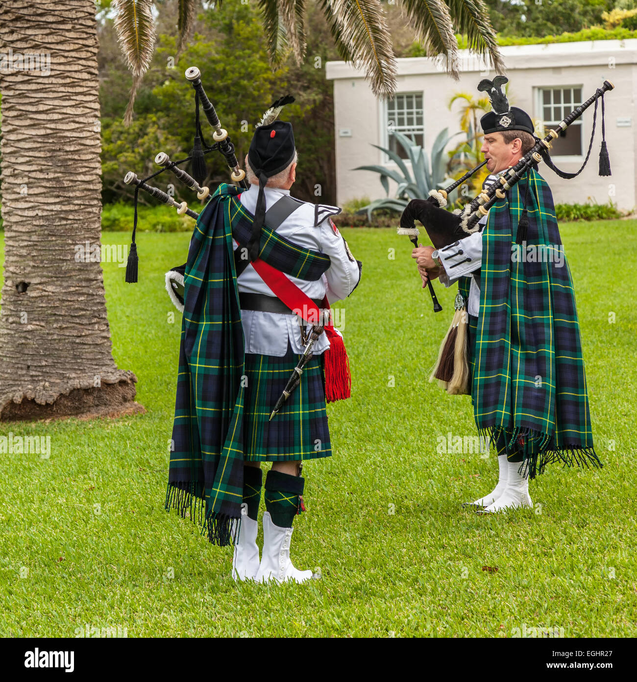Kilted members of the Bermuda Islands Pipe Band play bagpipes on the grounds of Fort Hamilton in Hamilton, Bermuda. Stock Photo