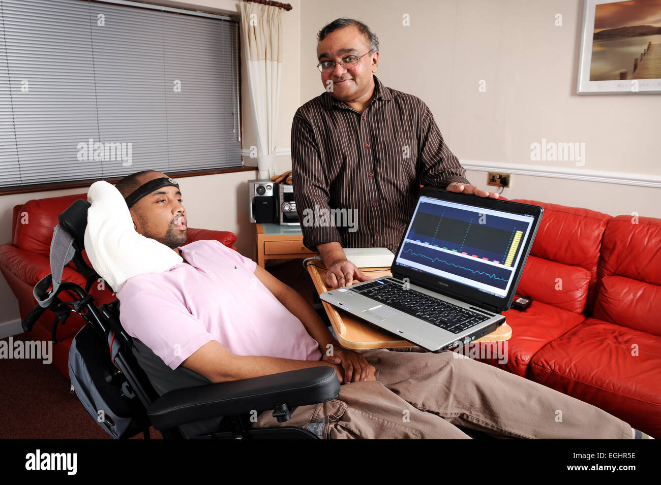 Richard Gregory has Locked-in Syndrome is pictured with Dr Gnanayathum, who's developed a device which interprets the brainwaves Stock Photo