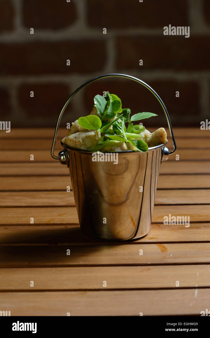 Tapas Lightly Spiced Chicken Strips with Spring Onions. Served in a bucket shape  steel bowl Stock Photo