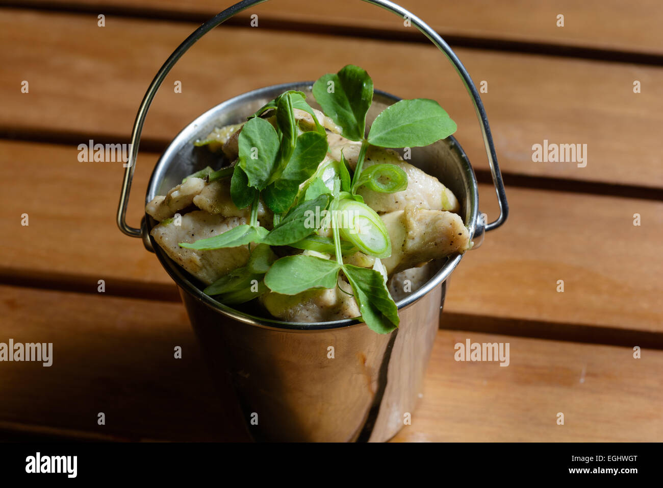 Tapas Lightly Spiced Chicken Strips with Spring Onions. Served in a bucket shape  steel bowl Stock Photo