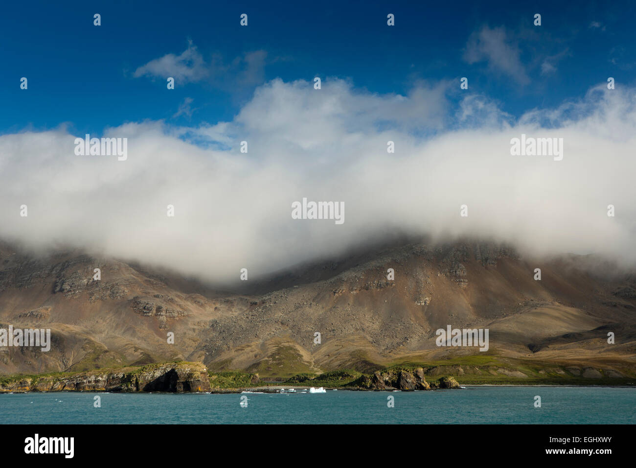 South Georgia, Cumberland Bay, Jason Harbour, band of cloud over coastal hills Stock Photo