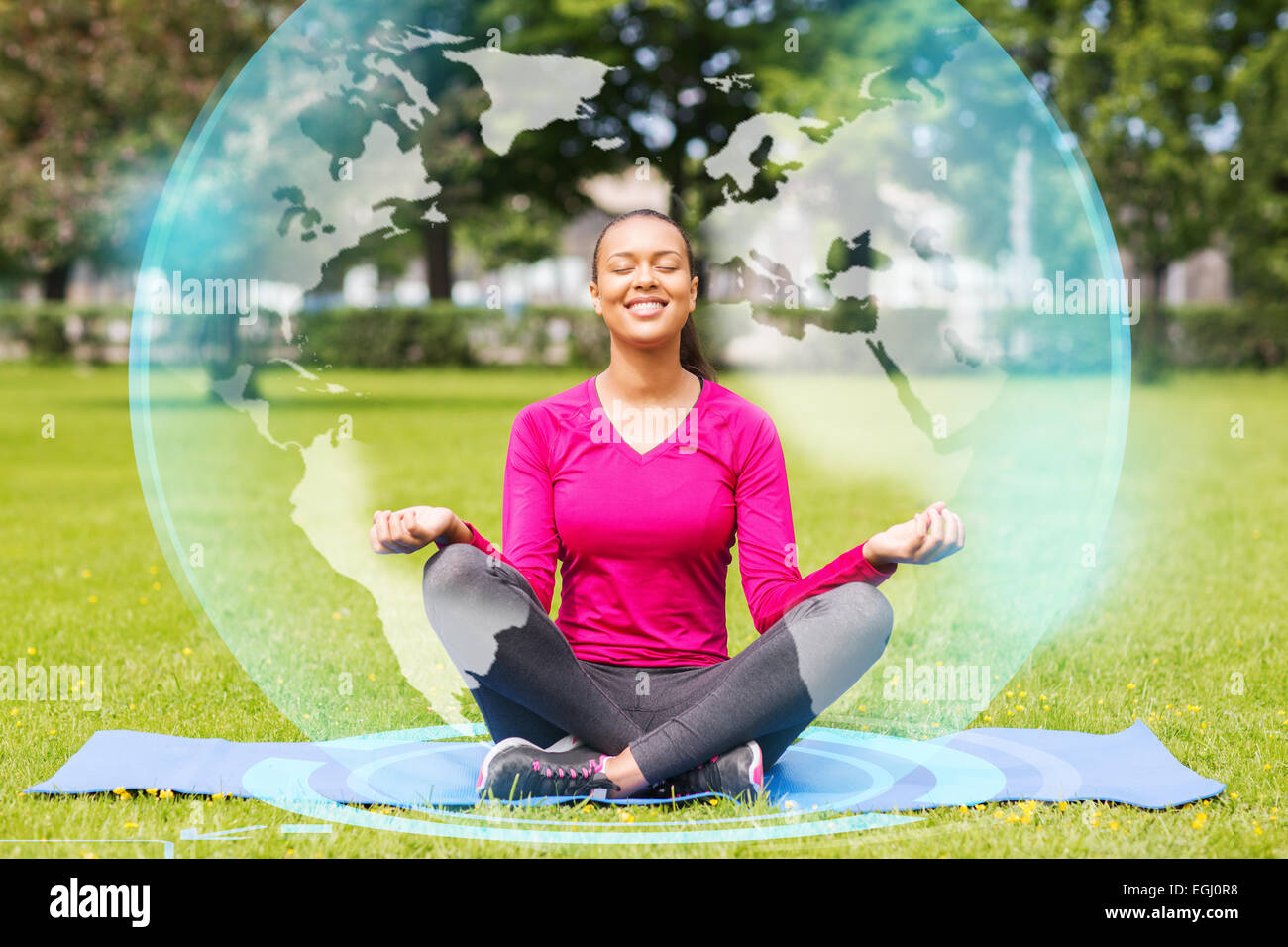 smiling woman meditating on mat outdoors Stock Photo - Alamy