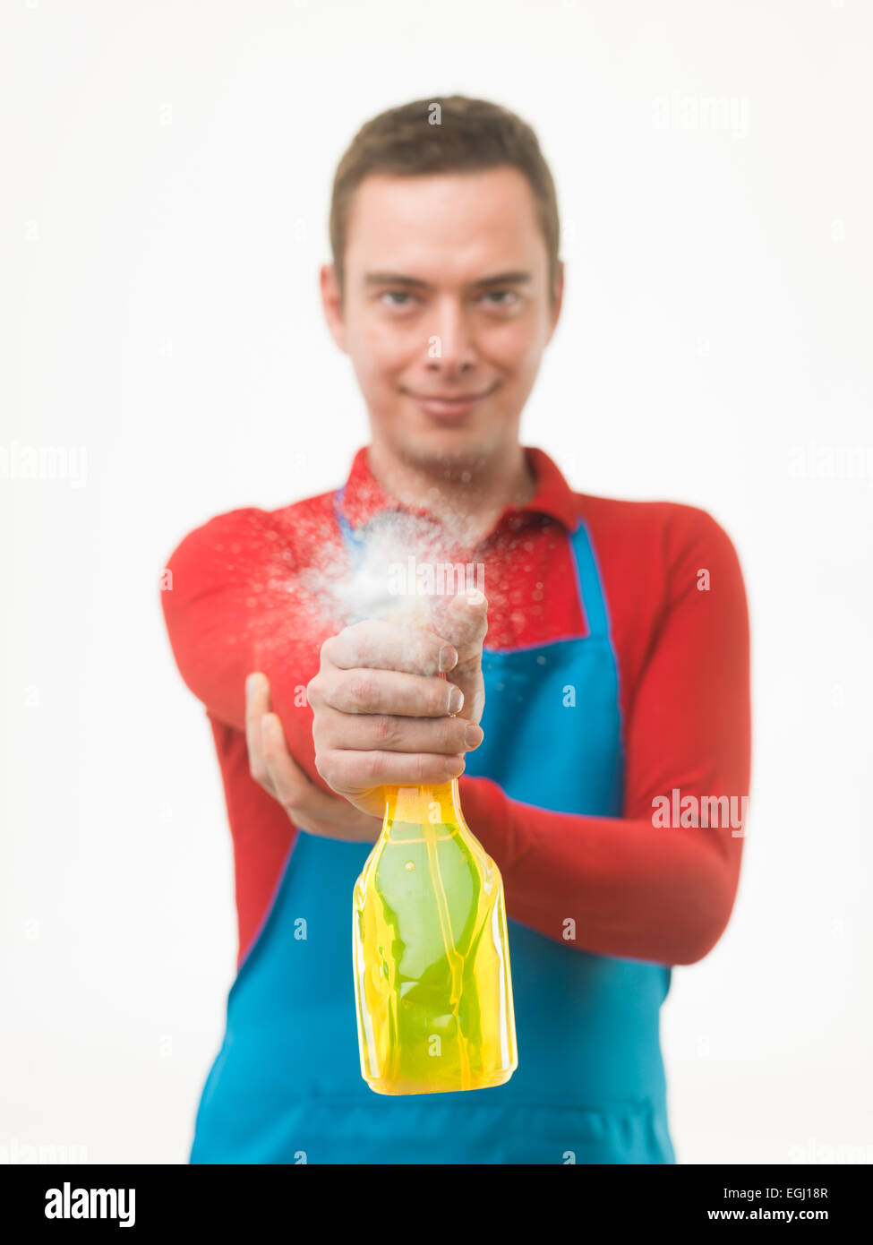 male cleaning worker spraying liquid detergent on window surface in front of him, on white background Stock Photo