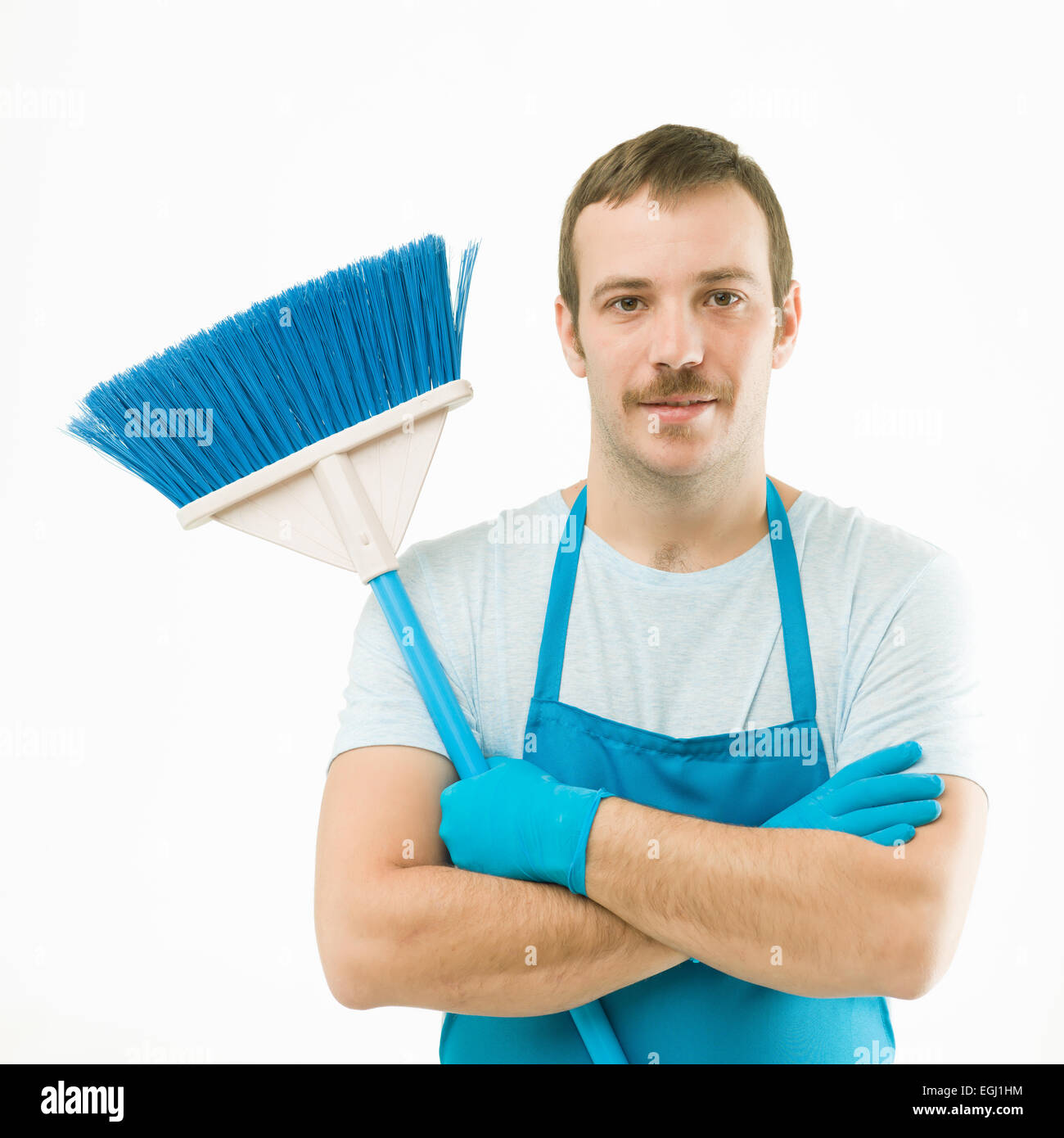 portrait of young caucasian cleaner holding broom with arms crossed, on