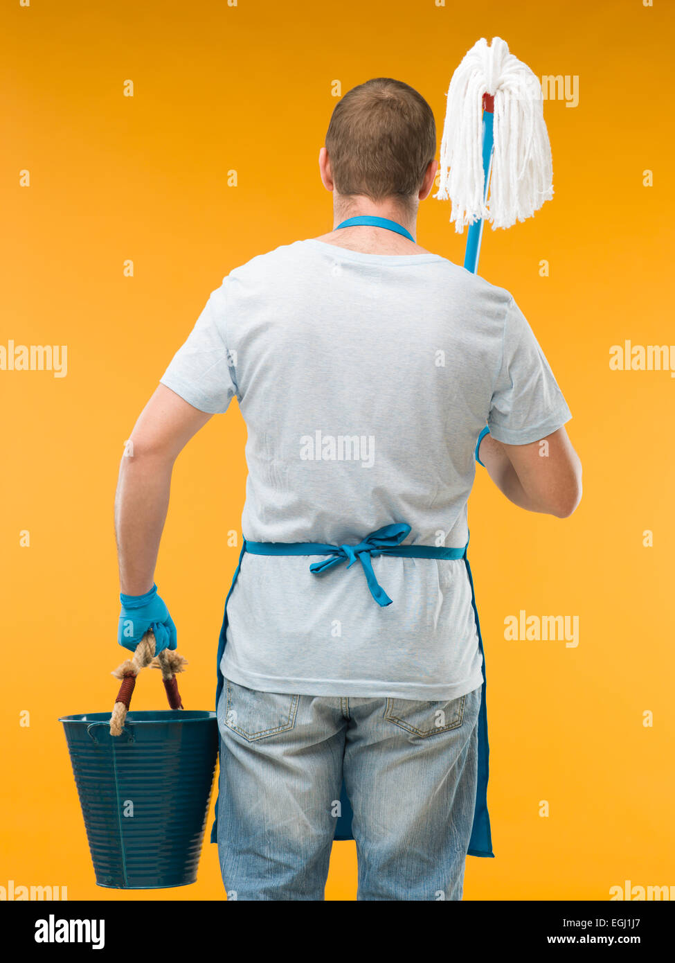 back view of caucasian male cleaner holding mop and bucket against yellow  background Stock Photo - Alamy