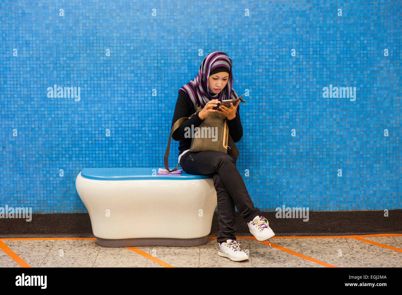 China, Hong Kong, Muslim Girl Using Smartphone Stock Photo