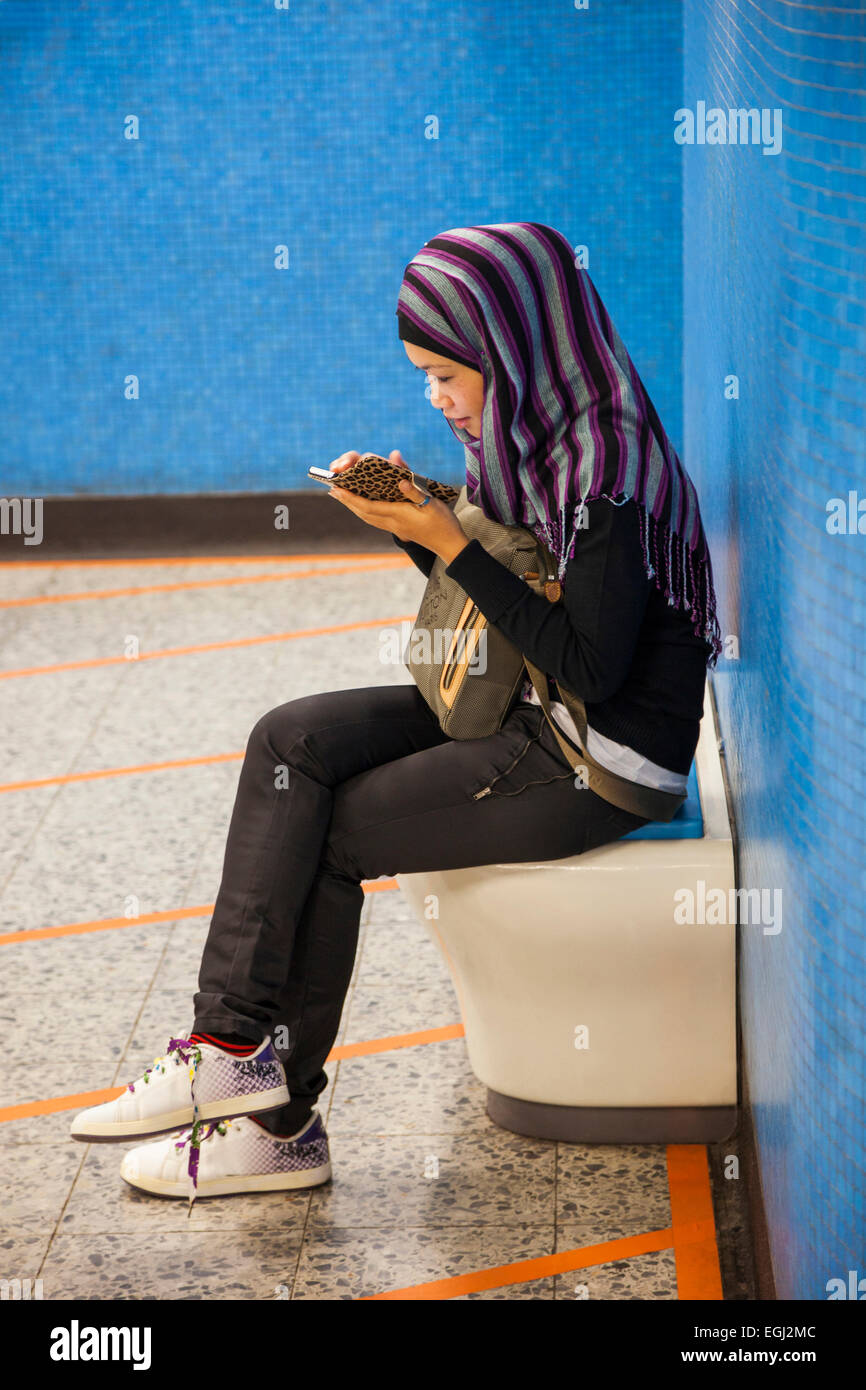 China, Hong Kong, Muslim Girl Using Smartphone Stock Photo
