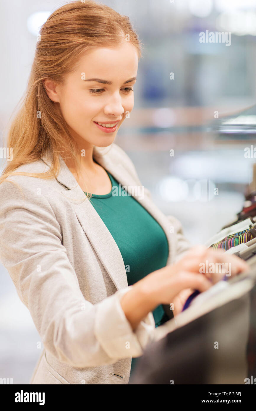 happy young woman choosing clothes in mall Stock Photo