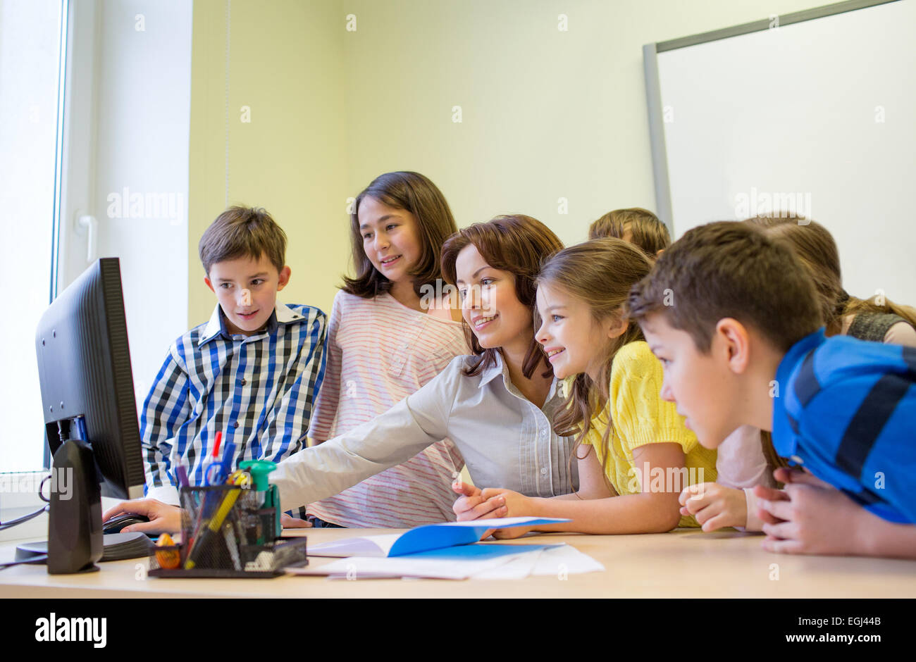 group of kids with teacher and computer at school Stock Photo - Alamy