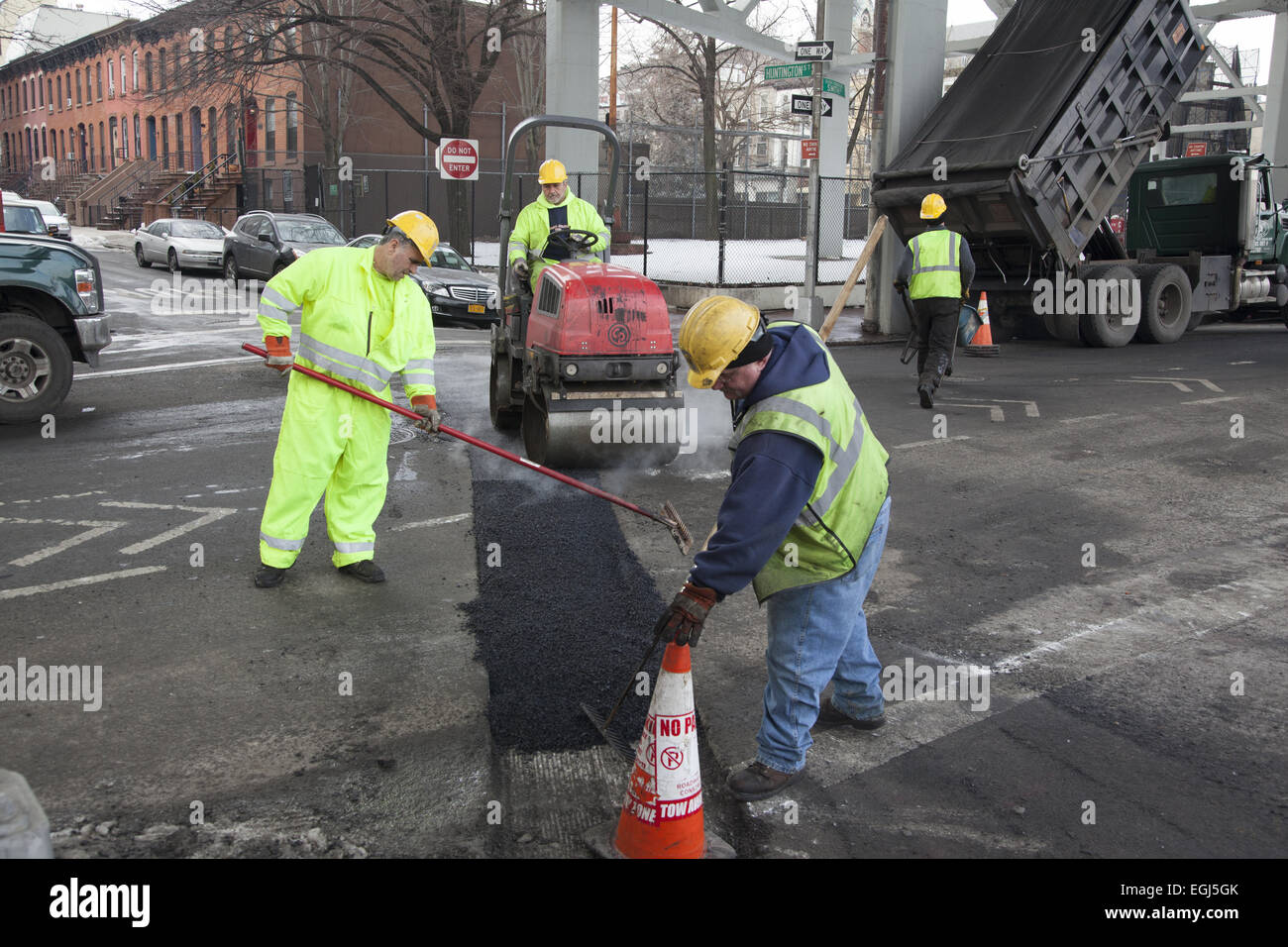 Workers fill in and repair a street that has new gas pipes underneath in the Carroll Gardens neighborhood of Brooklyn, NY. Stock Photo