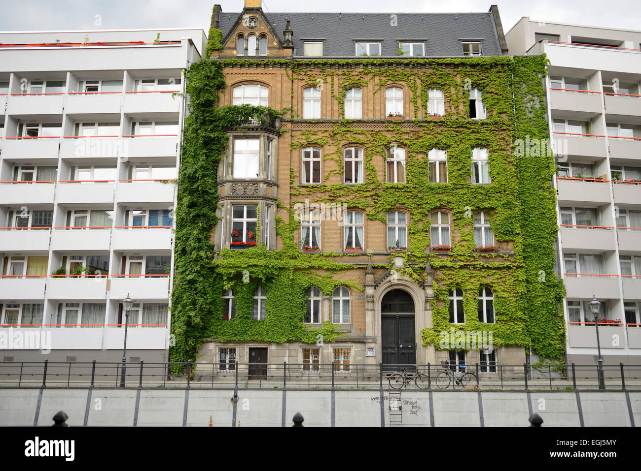 ivy-covered town house between two prefabricated buildings, Germany, Berlin Stock Photo