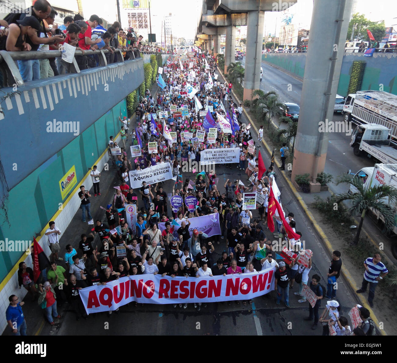 Militant protesters march towards the Cubao underpass on the historic EDSA highway, calling on President Benigno Aquino III to resign, during a rally at EDSA highway, held on the 29th anniversary of the 1986 People Power revolution. The protesters were blocked by police from reaching the police headquarters where they intended to form a 'human chain' from the headquarters to EDSA Shrine. Credit:  Richard James Mendoza/Pacific Press/Alamy Live News Stock Photo