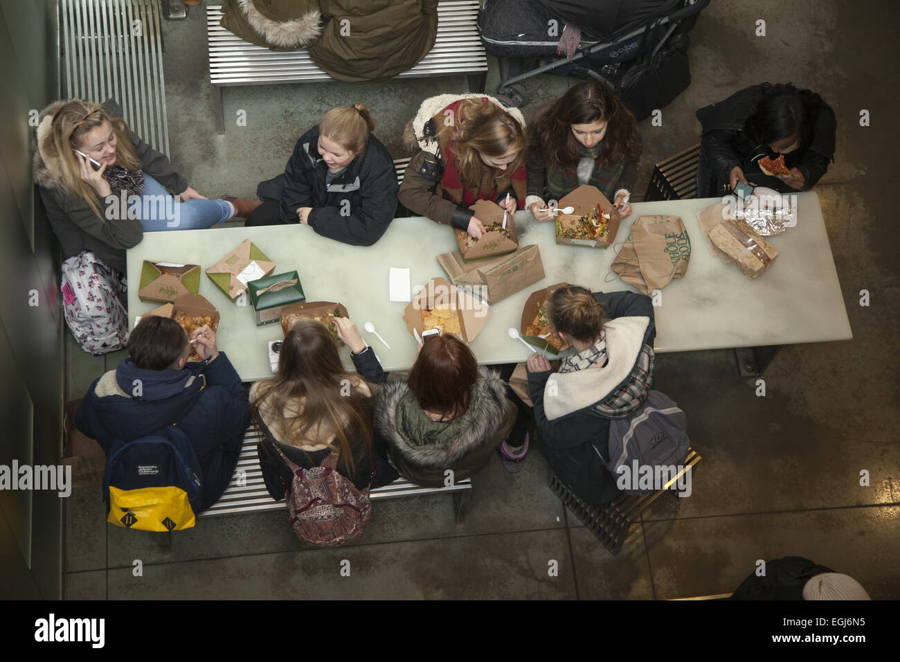 Group of teenage girls eat lunch together at the Whole Foods at Columbus Circle in Manhattan, NYC. Stock Photo