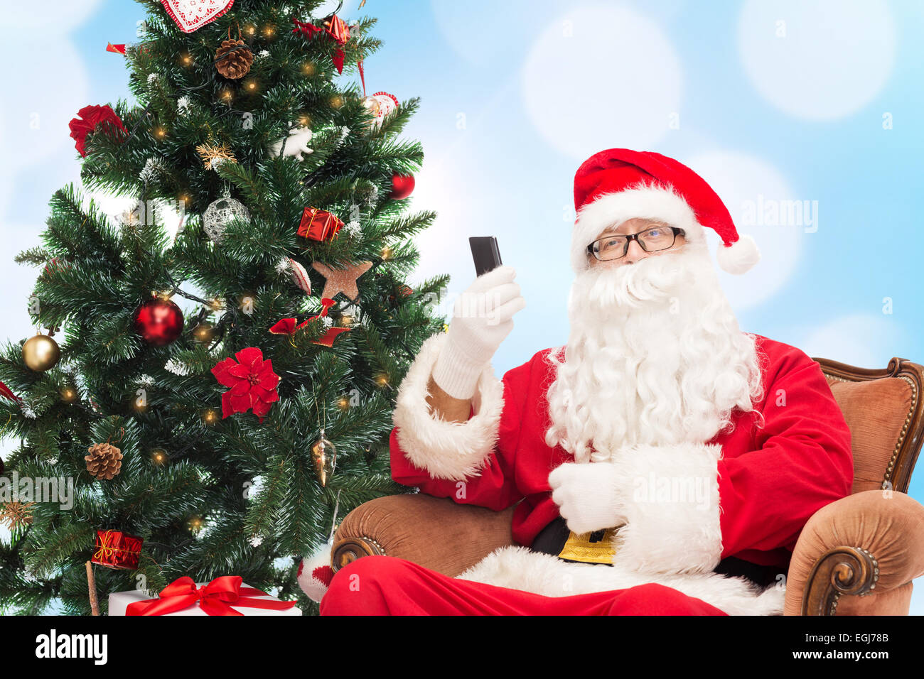 santa claus with smartphone and christmas tree Stock Photo - Alamy