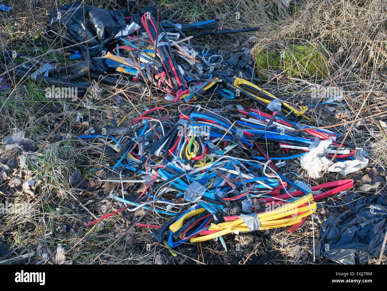 Discarded and dumped plastic cable casings from stripped wire seen adjacent to a footpath in Sunderland, north east England Stock Photo