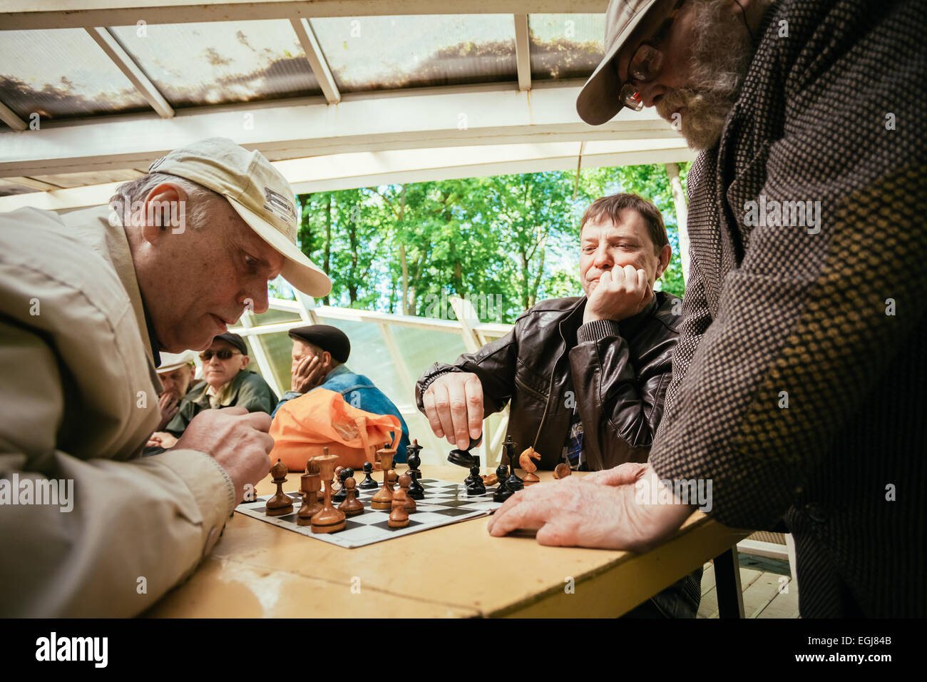 BELARUS, GOMEL - MAY 9, 2014: Active retired people, old friends and free time, senior men having fun and playing chess at city  Stock Photo