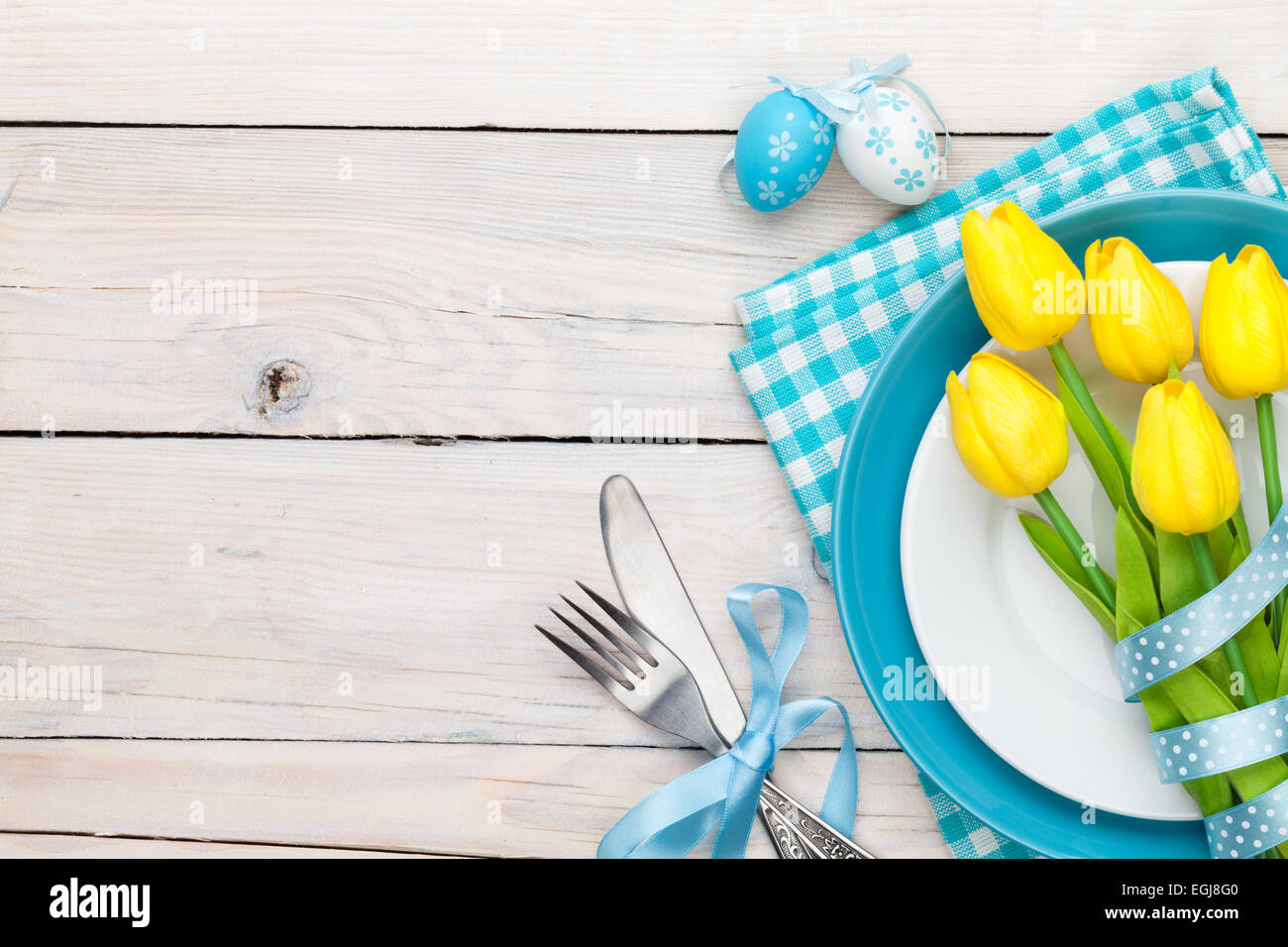 Easter background with yellow tulips and colorful eggs over white ...