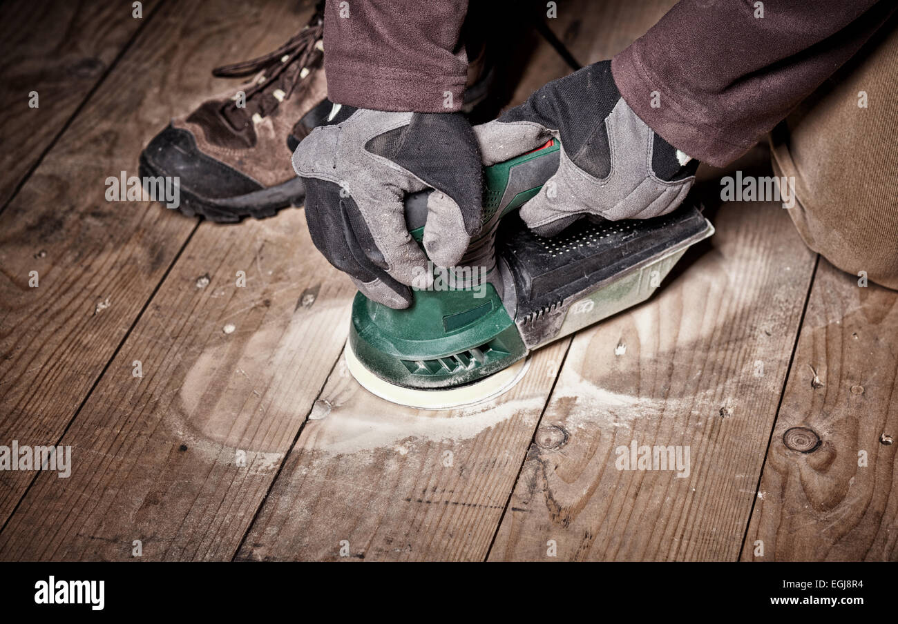 closeup of carpenter work with sander on wood floor Stock Photo