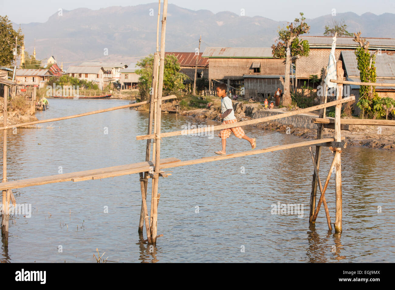 Crossing over waterway,canal at Inle Lake,on a bridge of basic makeshift planks of wood.Burma,Myanmar, Stock Photo