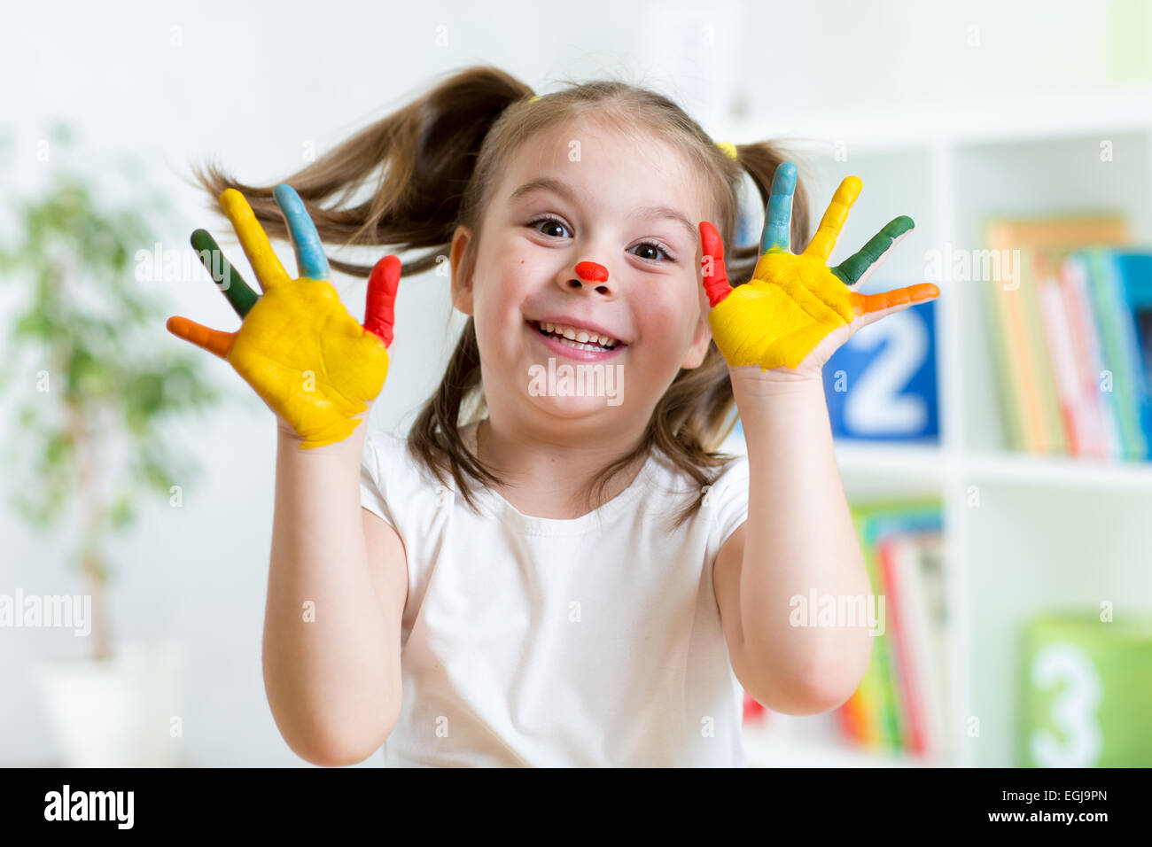 Funny kid with hands painted in colorful paint Stock Photo