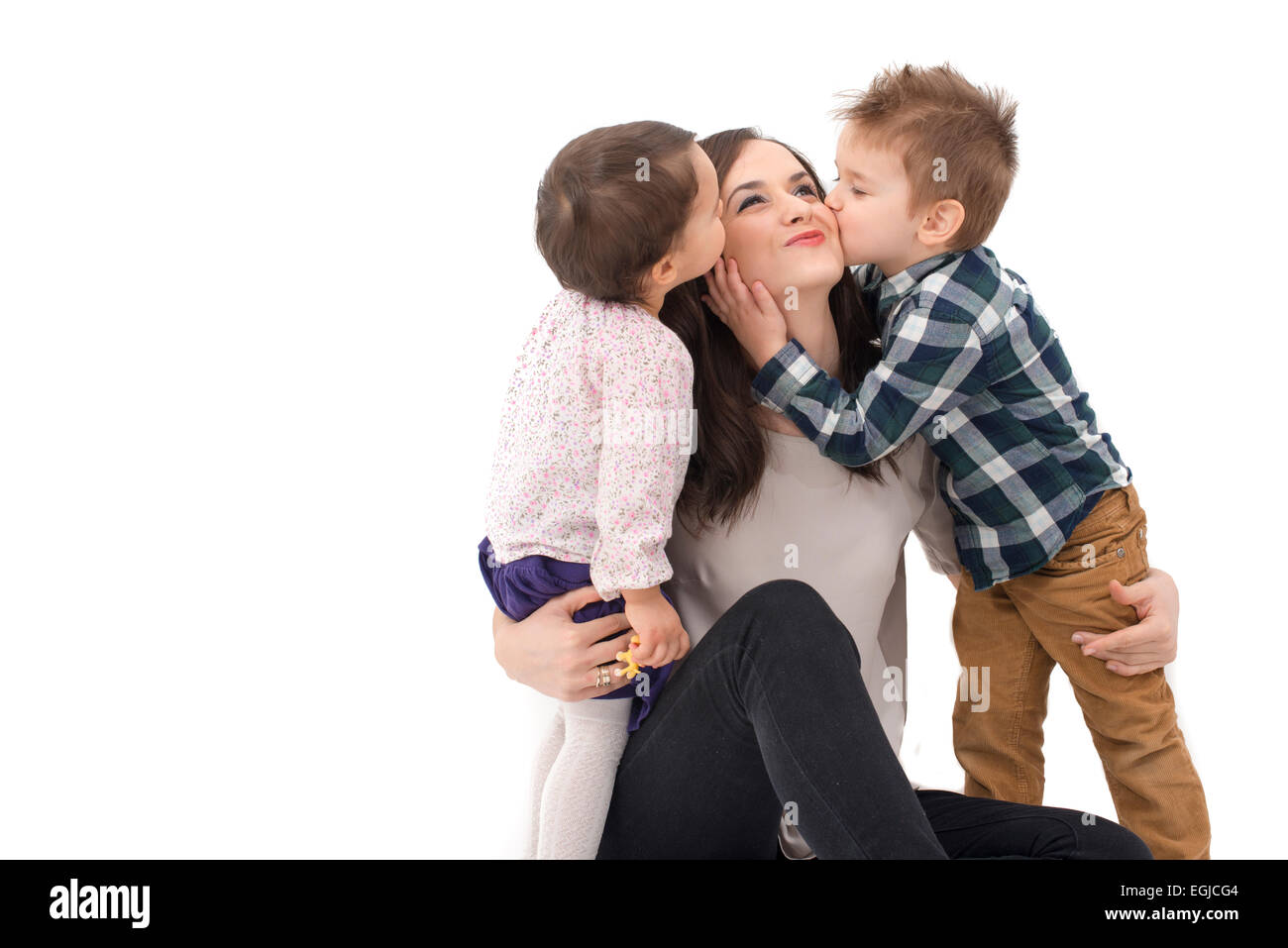 little girl and boy kissing their mother Stock Photo